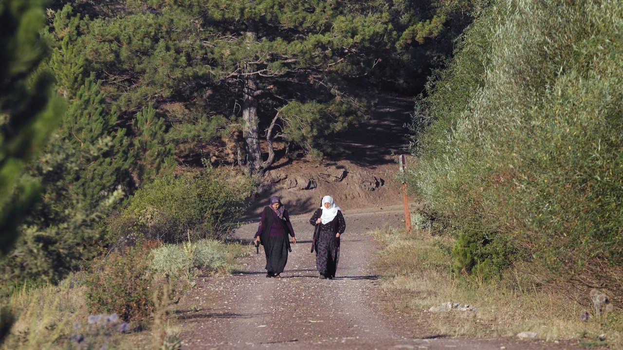 Two women in headscarfs carrying rifles
